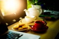 Coffee cup, tea pot , cookies and laptop Royalty Free Stock Photo