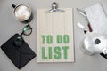 Coffee cup and to do list on grey desk from above, planning and Royalty Free Stock Photo