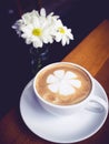 Coffee cup with White daisy flower decoration on wooden table