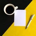 Coffee cup and white mockup blank on geometric black and yellow background, top view. Royalty Free Stock Photo