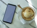 Coffee cup and white smartphone on rustic wooden table. Vintage cafe flat lay composition. Breakfast scene