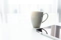 Coffee cup on white table with white window in the morning sunlight Royalty Free Stock Photo