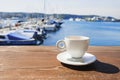 Coffee cup on a wood table over blue sky and sea background. Summer holiday concept Royalty Free Stock Photo