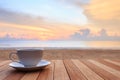 Coffee cup on wood table at sunset or sunrise beach Royalty Free Stock Photo