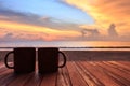 Coffee cup on wood table at sunset or sunrise beach Royalty Free Stock Photo