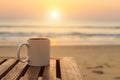 Coffee cup on wood table at sunset or sunrise beach Royalty Free Stock Photo
