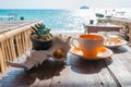 Coffee cup on the wooden table in front of the beach in a beautiful morning sunlight Royalty Free Stock Photo