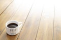 Coffee cup on a wooden table with a message of keep life simple