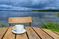 Coffee cup on wooden table near lake Royalty Free Stock Photo