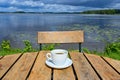 Coffee cup on wooden table near lake Royalty Free Stock Photo