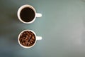 Coffee cups on green background  full of coffee beans and drink Royalty Free Stock Photo