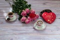 Coffee in cups, roses and a box of chocolates on a wooden table Royalty Free Stock Photo