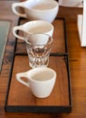 Coffee cups of various sizes next to tablet register in coffee shop on wooden background