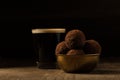 Coffee and dark chocolate truffles in golden bowl on wooden background. Royalty Free Stock Photo