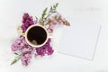 Coffee, different lilac flowers and white paper card