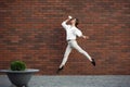 Jumping young woman in front of buildings, on the run in jump high Royalty Free Stock Photo