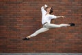 Jumping young woman in front of buildings, on the run in jump high Royalty Free Stock Photo