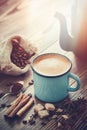 Coffee in enameled cup , sugar cubes, sack of coffee beans and spices.