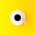 Coffee espresso in small white ceramic cup on yellow vibrant background. Minimalism Food Morning Energy Concept. Royalty Free Stock Photo