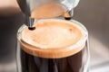 Coffee espresso streaming from coffee machine and pouring into glass Royalty Free Stock Photo