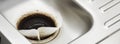 Coffee filter paper draining in kitchen sink plughole Royalty Free Stock Photo