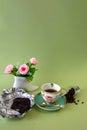 Coffee, flowers, candles on a pistachio background as a symbol of home warmth and coziness, beauty and a wonderful morning