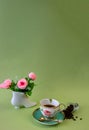 Coffee, flowers, candles on a pistachio background as a symbol of home warmth and coziness, beauty and a wonderful morning