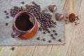 Coffee with foam in a brown clay cup, coffee beans and two heart-shaped candies on a wooden table Royalty Free Stock Photo