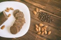 Coffee grains, almond nuts and chocolate pastry sausage on a wooden surface. Rustic still life Royalty Free Stock Photo