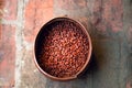 Coffee grains in an authentic iron bowl on a brick background, close-up, copy space