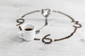 Coffee grains folded in the form of a clock on a wooden background. Instead of the number 7, a cup of coffee, which means it`s Royalty Free Stock Photo