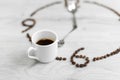 Coffee grains folded in the form of a clock on a wooden background. Instead of the number 7, a cup of coffee, which means it`s Royalty Free Stock Photo