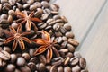 coffee grains and star anise on a wooden table, brown abstract background, warm texture, macro