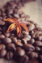 coffee grains and star anise on a wooden table, brown abstract background, warm texture, macro