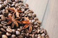 coffee grains and star anise on a wooden table, brown abstract background, warm texture, macro