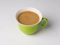 Coffee in a green cup on a white background. Beautiful creamy foam