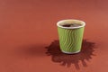 Coffee in green paper cup on brown background with stain. Spilled espresso on table. Glass with americano on coffee Royalty Free Stock Photo