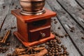 Coffee grinder with coffee beans and spices and spices cinnamon sticks, star anise on a wooden background Royalty Free Stock Photo