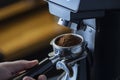 Coffee grinder grinding coffee pouring into a portafilter Royalty Free Stock Photo