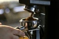 Coffee grinder grinding coffee pouring into a portafilter Royalty Free Stock Photo