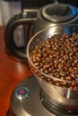 Coffee grinder with red start button, filled with fresh coffee beans, closeup, details Royalty Free Stock Photo