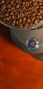 Coffee grinder with red start button, filled with fresh coffee beans and copy space in background for text, abstract, details Royalty Free Stock Photo