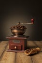 Coffee grinder and roasted coffee beans on a wooden table