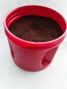 Coffee grinds in a red container isolated on a white background