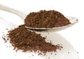 Coffee grounds in and around spoon isolated with white background Royalty Free Stock Photo