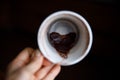 coffee grounds in shape of heart on bottom of cup. Fortune teller hand hold cup Royalty Free Stock Photo