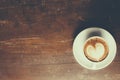 Coffee with heart pattern in a white cup on wooden background Royalty Free Stock Photo