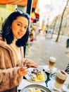 Young pretty brunette woman eating ice cream at the street cafe at Paris, France. Outdoor lifestyle portrait. Royalty Free Stock Photo