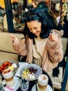 Young pretty brunette woman eating ice cream at the street cafe at Paris, France. Outdoor lifestyle portrait. Royalty Free Stock Photo