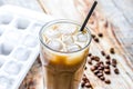 coffee ice cubes and beans with latte on wooden desk background Royalty Free Stock Photo